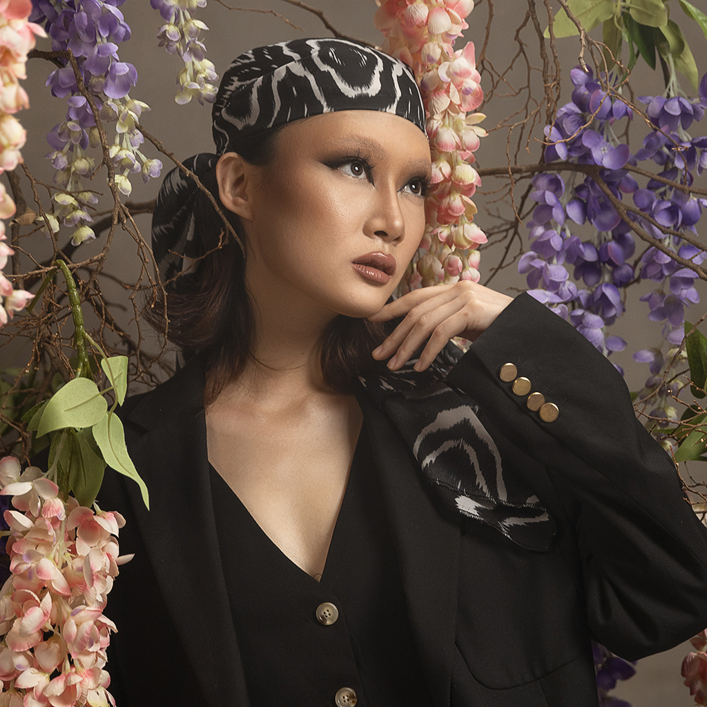 image of a young woman in bandana with wisteria flowers in background